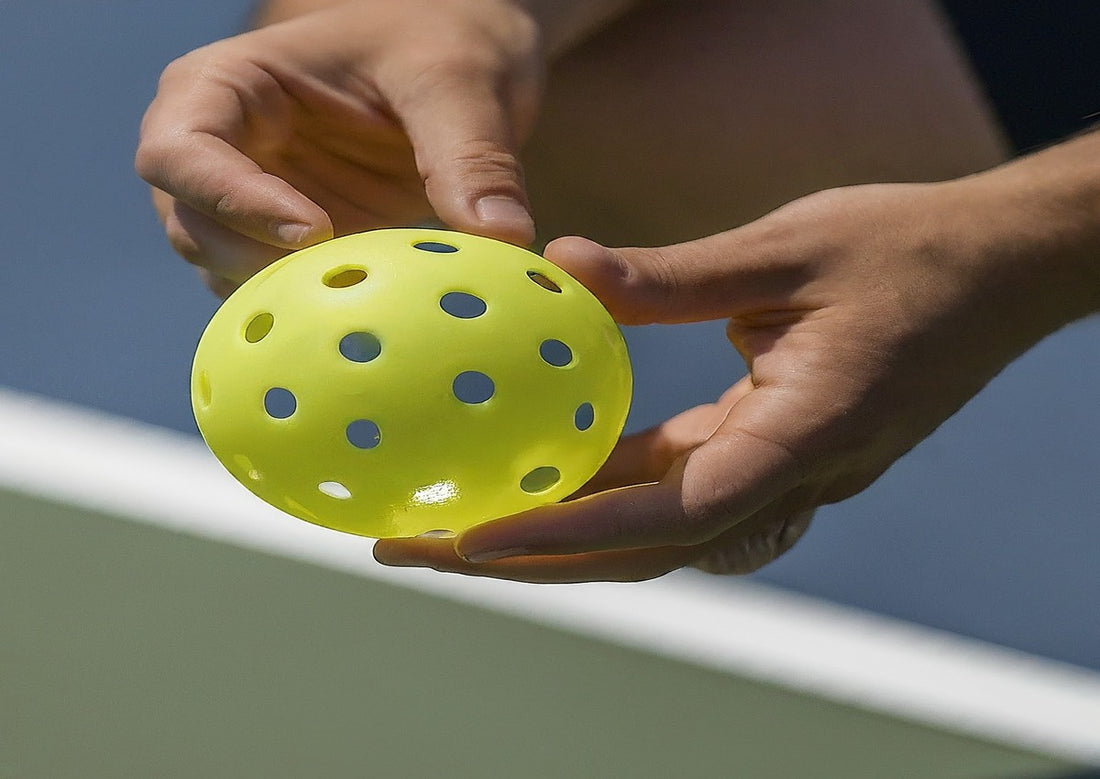 A person holding a type of pickleball ball